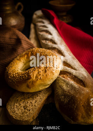 Du pain fraîchement sorti du four en brique - Photographie sombre Banque D'Images