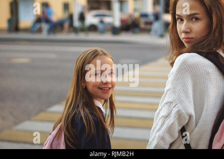 Deux sœurs adolescentes mignonnes on city street. Les filles sont debout près de passage pour piétons à travers l'autoroute. Le code de la route. Banque D'Images