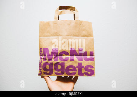 PARIS, FRANCE - Aug 29, 2018 : Crop part montrant brown paper de McDonalds avec McNuggets sac avec shop publicité sur le côté contre fond blanc Banque D'Images