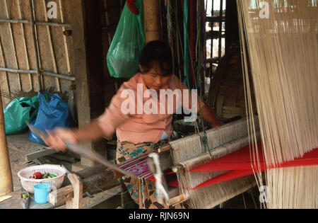 Un village dame coton tisse sur un métier dans le nord du Laos. A l'artisanat traditionnel, le tissage a été un retour au cours des dernières années que le tourisme infil Banque D'Images