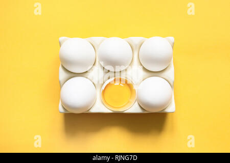 Chiken blanc biologique œufs dans boîte décorative en porcelaine sur jaune. Vue d'en haut. Des aliments sains et naturels concept organique. Banque D'Images