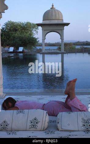 Légende : Udaipur, Rajasthan, Inde - mai 2003. Un invité à vous détendre dans le cadre palatial autour de Udaivilas's piscine. Un impeccable six étoiles Banque D'Images