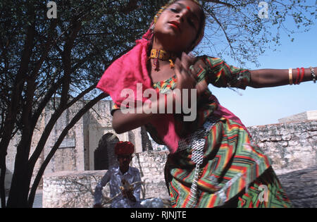 Légende : Jodphur, Rajasthan, Inde - avril 2003. Un jeune musicien ambulant girl dancing à la musique folklorique a joué par son père à l'extérieur du fort Mehranghar je Banque D'Images