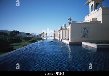 Légende : Udaipur, Rajasthan, Inde - mai 2003. Un invité est la natation dans les douves de piscine qui s'étend le long de la face de l'Oberoi Udaivilas, un nouveau combat Banque D'Images