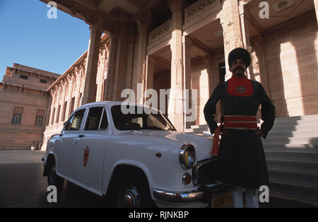 Légende : Jodphur, Rajasthan, Inde - avril 2003. Un hôtel porter et voiture à l'extérieur de l'Ambassadeur Jodphur Palais Royal, l'Umaid Bhawan. Construit au cours de la FIRS Banque D'Images