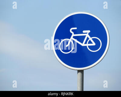 Location panneau routier isolé sur ciel bleu. Vélo blanc symbole sur le cercle bleu de signer Banque D'Images