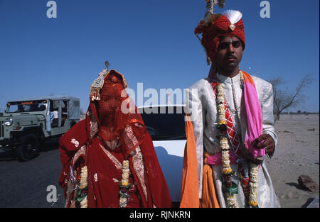 Légende : Bikaner, Rajasthan, Inde - avril 2003. Un couple du Rajasthan après leur cérémonie de mariage conduite sur le bord d'un higheay près de Bikaner, weste Banque D'Images