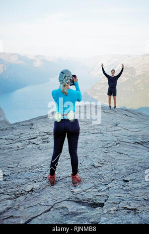 Les touristes Instagram - la prise d'un téléphone mobile shot sur les médias sociaux sur le dessus de l'Pulpit Rock / Preikestolen ou Prekestolen viewpoint en Norvège Banque D'Images