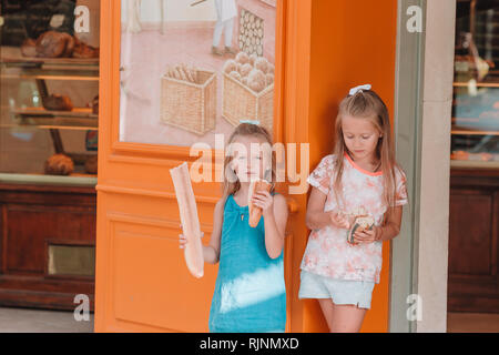 Les petits enfants avec Cutiest baguette croustillante frais dans une boulangerie à Paris Banque D'Images