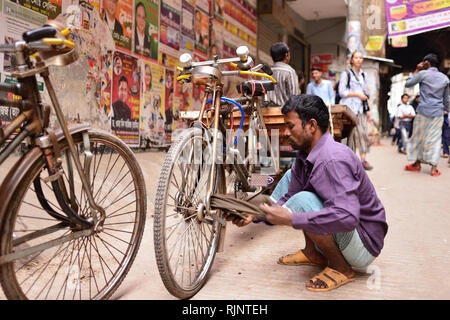 DHAKA, BANGLADESH BENGALE - 28 janvier 2019 : conducteur de pousse-pousse est le nettoyage de roues dans son pousse-pousse sur les rues de Dhaka au Bangladesh Le Banque D'Images