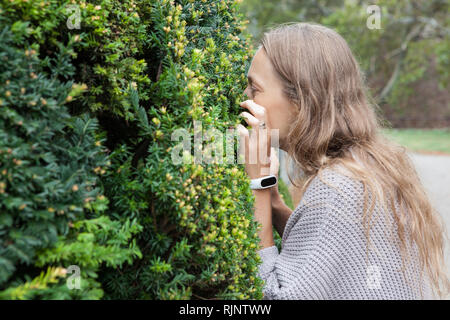 L'inhalation de fille une usine dans le parc Banque D'Images