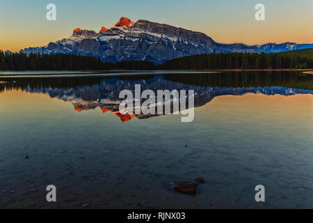 Les montagnes enneigées se reflètent dans le lac et deux Jake créent une atmosphère unique. Banque D'Images