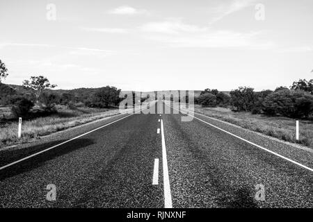 Vide tout droit sur la route asphaltée à travers l'outback australien. Image en noir et blanc. Banque D'Images