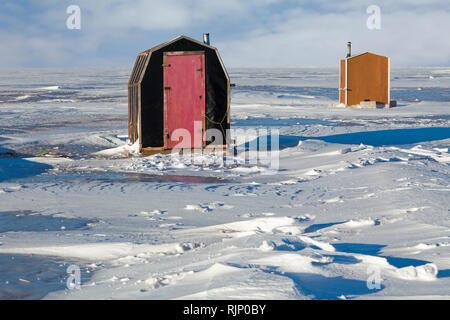 Des cabanes de pêche sur glace "fondre" sur la glace le long des rives de l'Île du Prince Édouard, Canada. Banque D'Images