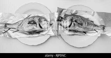 Grande image de deux la dorade poisson sur la feuille d'aluminium sur le tableau blanc - Vue de dessus de délicieux plats fait maison - retour et blanc Banque D'Images