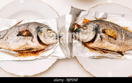 Deux la dorade poisson sur la feuille d'aluminium sur le tableau blanc - Vue de dessus de la nourriture délicieuse filtre maison style instagram Banque D'Images