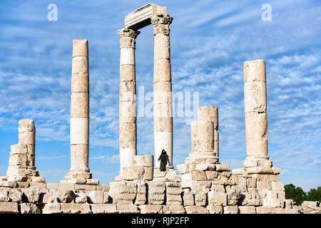 Une fille est posant pour une photo en face de quelques magnifiques colonnes de la Citadelle d'Amman, en Jordanie. Banque D'Images