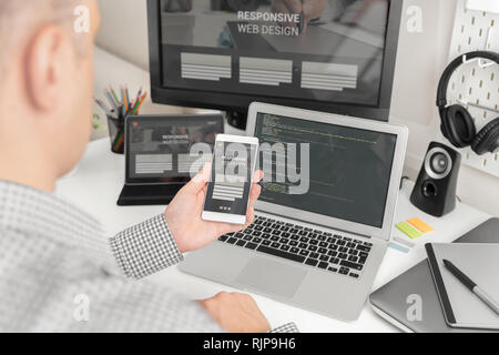 Web designer, programmeur travaillant avec modèle responsive web. Plusieurs appareils sur 24. Banque D'Images