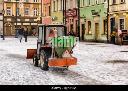 Petit tracteur équipé d'un chasse-neige et les saleuses applique de sel à la sentier, Wroclaw, Wroclaw, Wroklaw, Pologne Banque D'Images