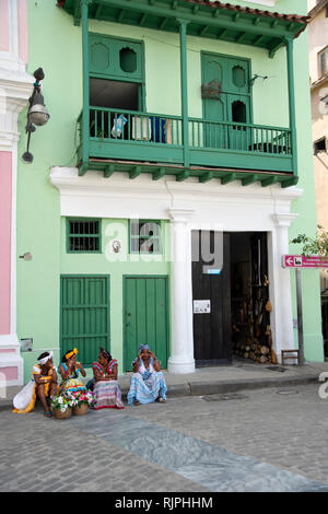 Quatre femmes cubaines habillé pour les touristes s'asseoir sur le pas d'un vieux bâtiment dans la Habana Vieja Cuba Banque D'Images