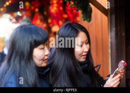 Mère et fille window shopping au marché de Noël, Freiburg, Baden-Wurttemberg, Allemagne Banque D'Images