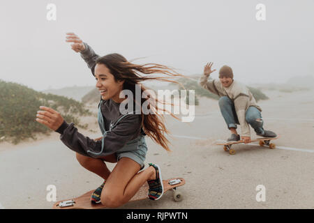 Jeune couple en planche à roulettes, parking plage misty Jalama, California, USA Banque D'Images