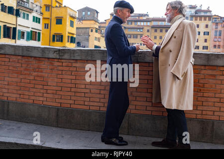 Deux messieurs habillés avec élégance engagé la conversation sur les rives du fleuve Arno Florence Italie Banque D'Images