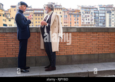 Deux messieurs habillés avec élégance engagé la conversation sur les rives du fleuve Arno Florence Italie Banque D'Images