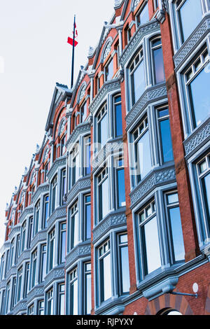 Ottawa, Ontario, Canada, novembre 2018 - la façade de l'immeuble en brique rouge avec windows et au centre-ville de . Drapeau du Canada au sommet de l'immeuble Banque D'Images