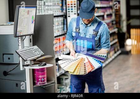 Portrait of a handsome workman avec échantillons de couleur à proximité de l'équipement pour colorer dans le bâtiment shop Banque D'Images