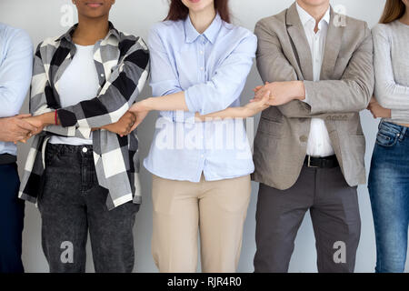 Les gens d'affaires diversifié permanent groupe Holding Hands, Close up view Banque D'Images