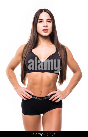 Portrait de jeune femme avec ses mains sur les hanches à la recherche à l'appareil photo. Femme de remise en forme musculaire avec corps en état d'exercice isolé sur fond blanc Banque D'Images