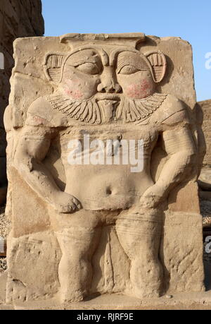 Sculpture Relief du dieu égyptien, BES dans l'avant-cour du temple d'Hathor à Dendérah. Le nain-comme dieu était considéré comme le protecteur des femmes enceintes, les nouveau-nés, et la famille. Le soulagement des dates à la période Ptolemaic-Roman Banque D'Images