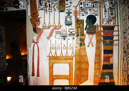 Peinture murale représentant, Nefertari et le Dieu, Ptah. L'intérieur de la tombe (QV66) de Nefertari, Grande épouse du pharaon Ramsès II, l'Égypte Vallée des Reines. Il a été découvert par Ernesto Schiaparelli en 1904. Elle est appelée la Chapelle Sixtine de l'Égypte ancienne. Dans la Vallée des Reines, tombe de Nefertari tenue une fois le corps momifié et représentatif de ses symbolismes, comme ce que la plupart des tombeaux égyptiens se composait de. Maintenant, tout avait été pillé à l'exception de deux tiers des 5 200 pieds carrés de peintures murales. ca. 1255 BC Banque D'Images