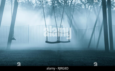 Balançoires en parc public sur un matin brumeux. UK Banque D'Images