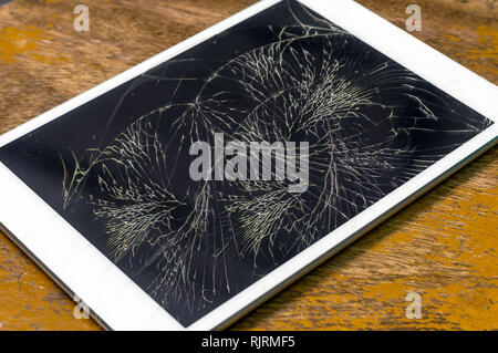 Ordinateur tablette avec écran de verre cassée sur le fond en bois Banque D'Images