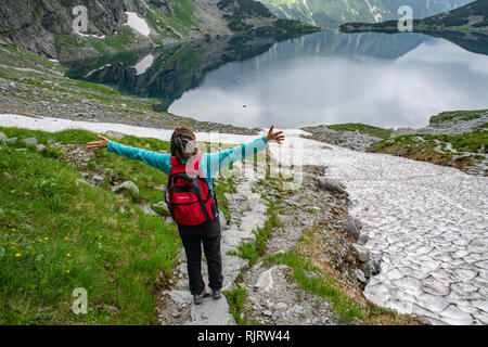 Pose d'un randonneur sur le côté de Mt. Rysy près de Czarny Staw pod Rysami (Lac Noir) dans le Parc National des Tatras,lesser Poland Vovoidship, Pologne. Banque D'Images