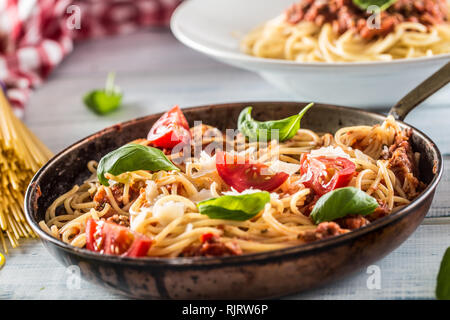 Les pâtes italiennes spaghetti bolognese en vieille casserole de tomates et basilic et parmesan Banque D'Images