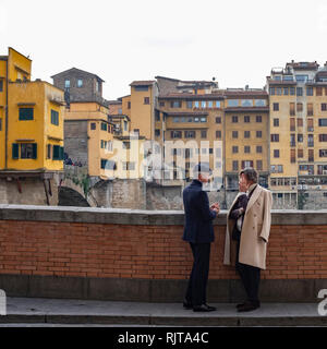 Deux messieurs habillés avec élégance engagé la conversation sur les rives du fleuve Arno Florence Italie Banque D'Images