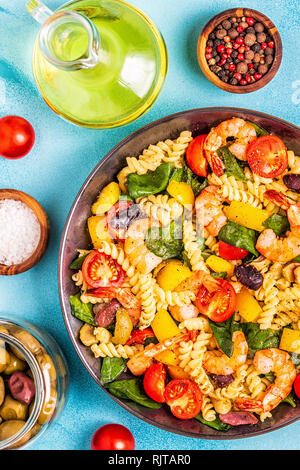 Salade de pâtes fusilli aux crevettes, tomates, poivrons, épinards, olives, vue d'en haut. Banque D'Images