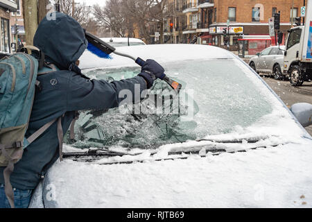 Montréal, Canada - 7 Février 2019 : voiture nettoyage de la glace du pare-brise avec grattoir outil. Banque D'Images