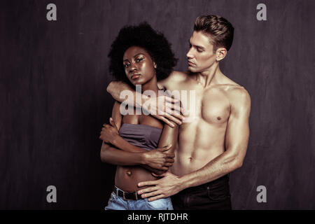 Belle blonde bien construit man hugging son amie Banque D'Images