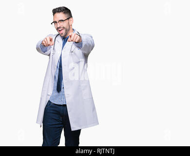 Beau jeune homme médecin sur fond isolé pointant vers vous et l'appareil photo avec les doigts, souriant et de bonne humeur positive Banque D'Images