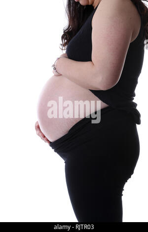 Profil latéral de la jeune mère enceinte avec mains tenant son bébé dans le ventre avec l'exemplaire de l'espace. Isolé sur fond blanc. Banque D'Images