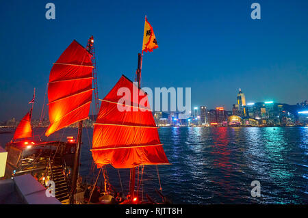 HONG KONG - le 25 janvier 2016 : les voiles rouges d'Aqua Luna au crépuscule. L'Aqua Luna est une jonque chinoise opérant dans le port de Victoria. Banque D'Images