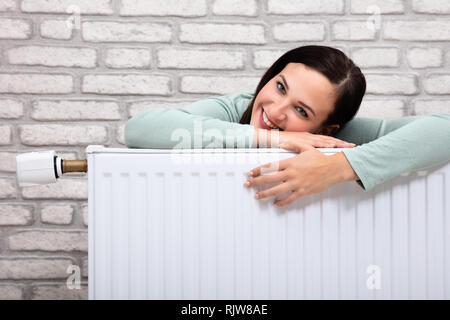 Portrait Of A Young Woman Leaning On radiateur de chauffage Banque D'Images