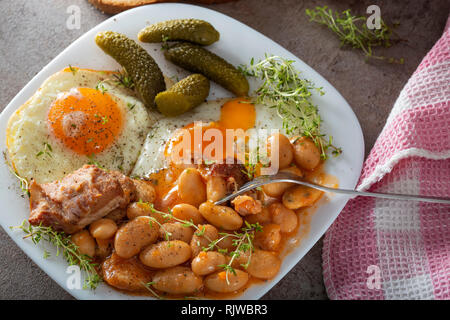 Manger des haricots avec de la viande de porc fumé, des oeufs et des cornichons - Vue de dessus Banque D'Images