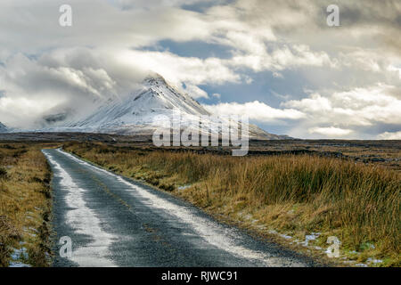 Photo d'une route de montagne à distance aller à la montagne couverte de neige Errigal à Donegal en Irlande. Banque D'Images