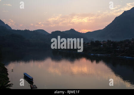 Avec le coucher du soleil sur la rivière Nam Ou en bateau au village de Nong Khiaw le guest house, une populaire destination voyage de randonneur près de Luang Prabang au Laos Banque D'Images