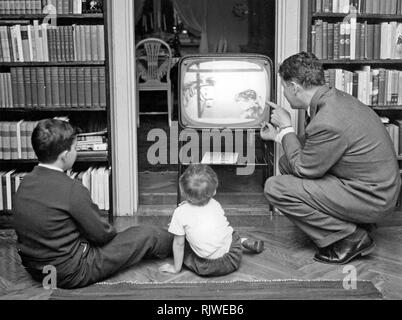 La télévision dans les années 1950. Un père avec ses enfants devant la télé en regardant un programme pour enfants. Suède 1958 Banque D'Images